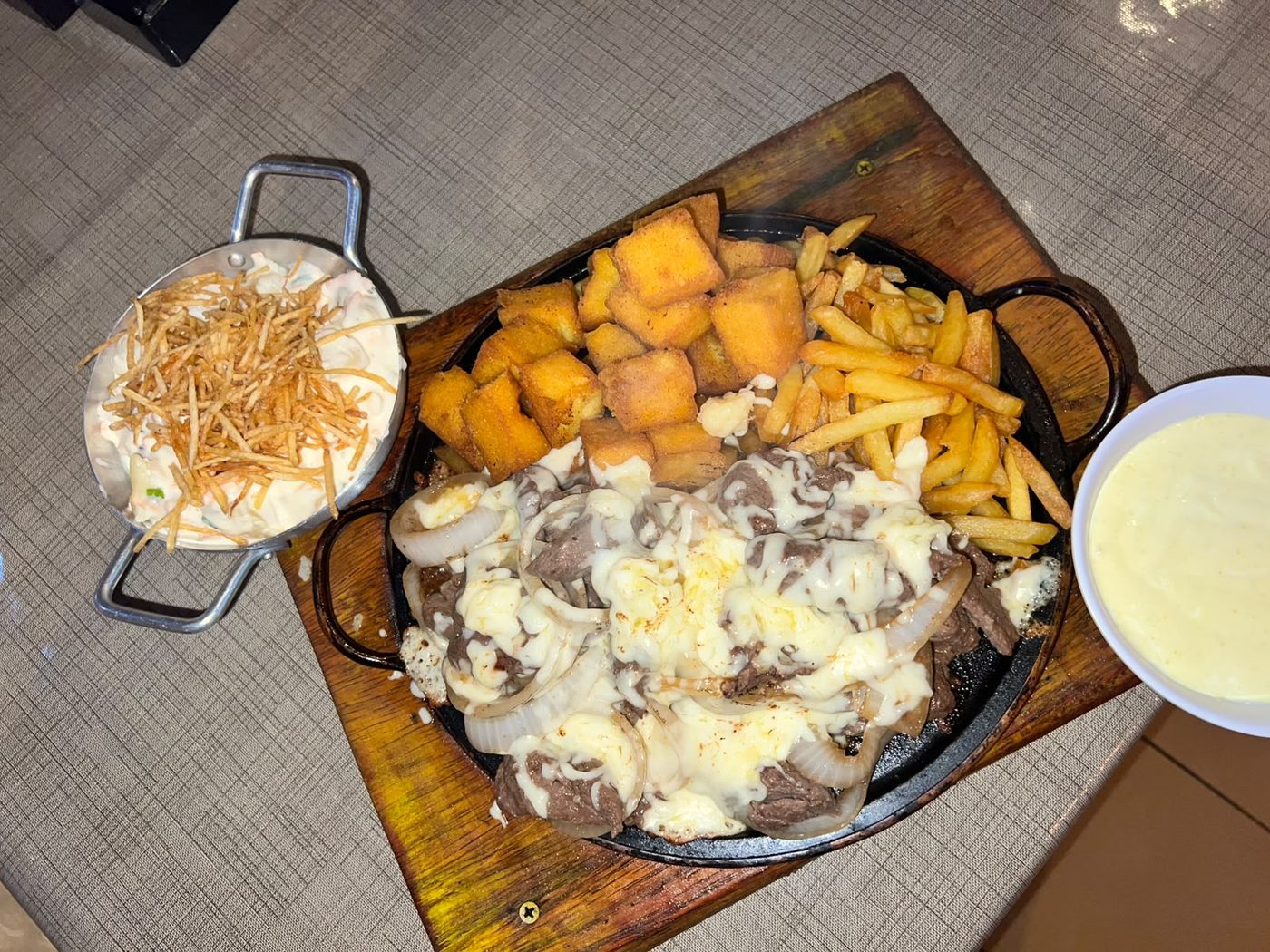 Filé na chapa com queijo, fritas, polenta e batata palha