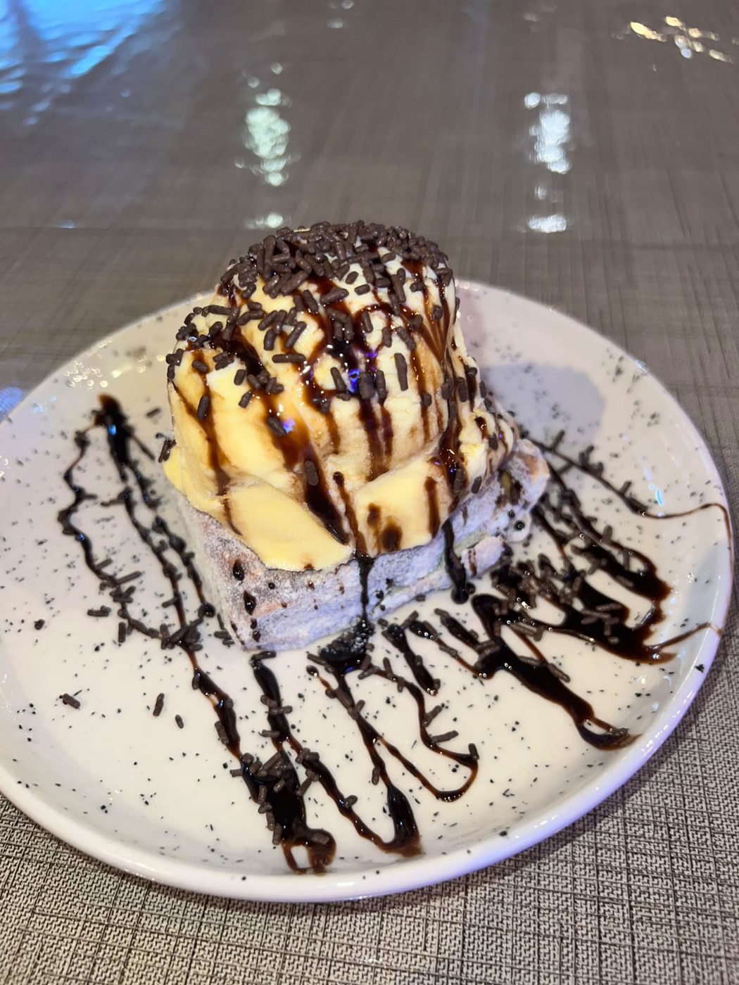 Sobremesa com sorvete, calda de chocolate e granulado
